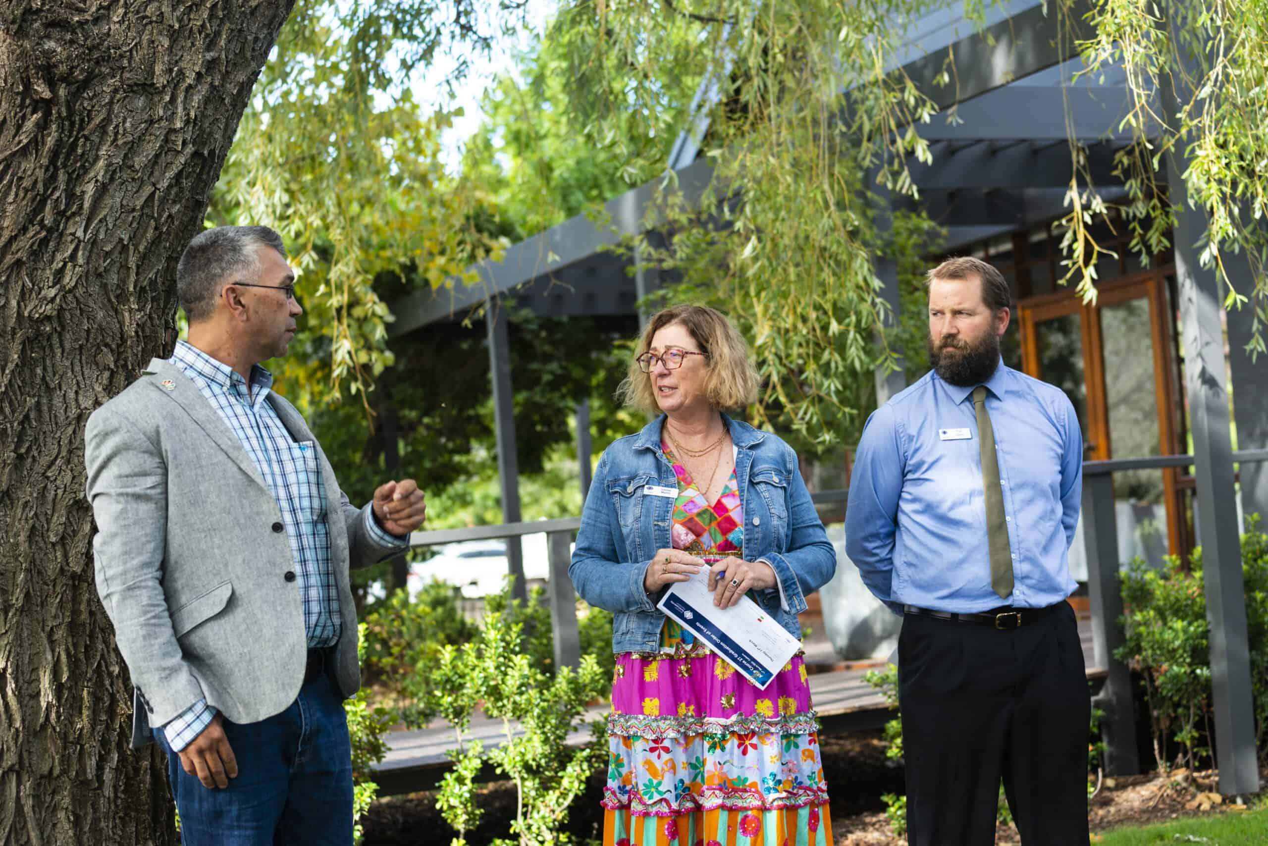 Three adults having a conversation outside during a program