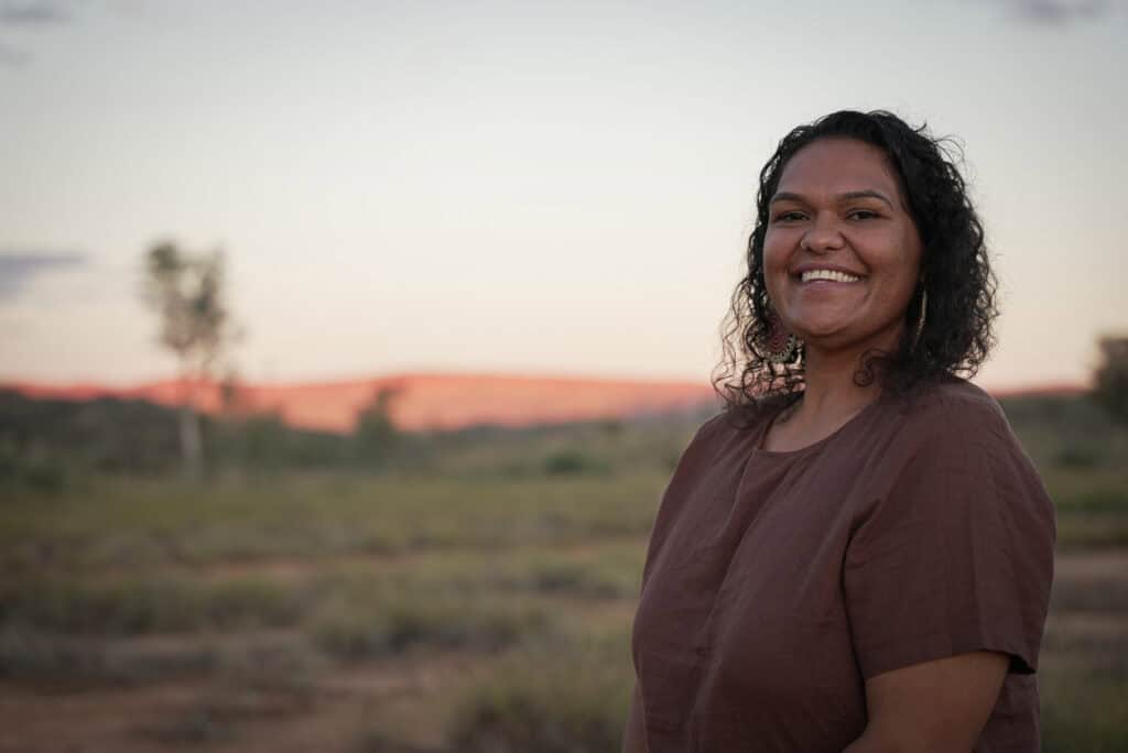 Photo of Cherisse Buzzacott in the Australian Outback smiling at camera