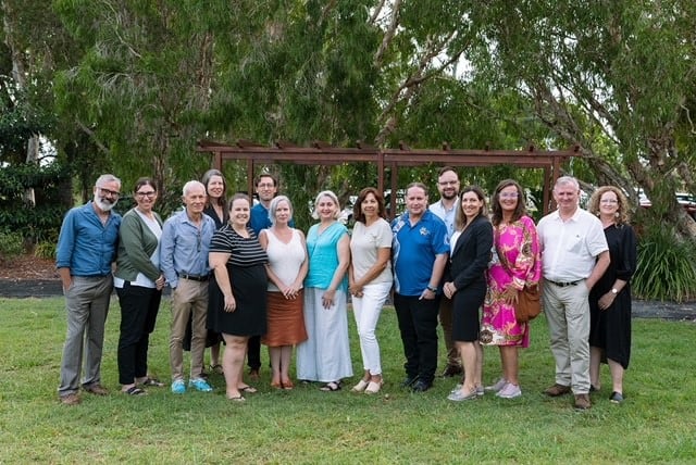 A group of Northern Rivers Leading Australian Resilient Communities program alumni standing in a park in front of trees.