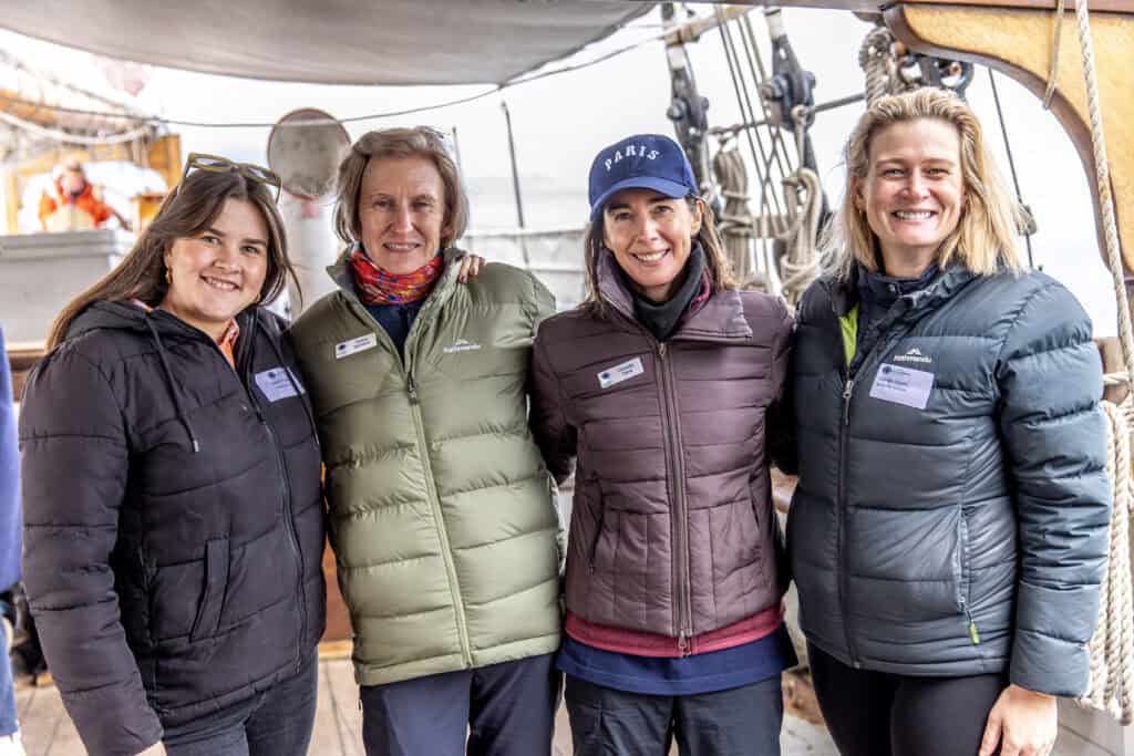 Four women on a boat smiling