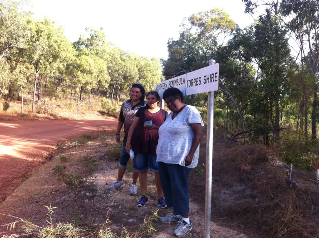 Women standing in front of sign in Torres Strait