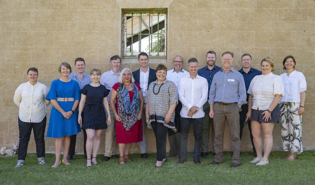 A group of Leading Australian Resilient Communities program participants standing in front of a building wall.